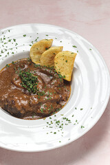 Homemade stew of osso buco meat with aromatic herb sauce