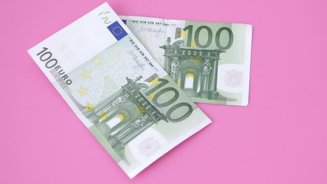100 euro bills on pink background. close-up