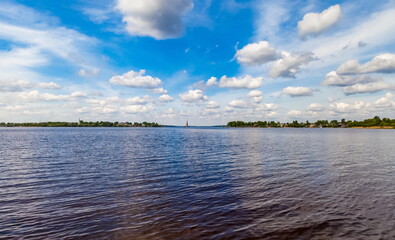 Summer landscape: River, sky, clouds, Church bell tower on the water