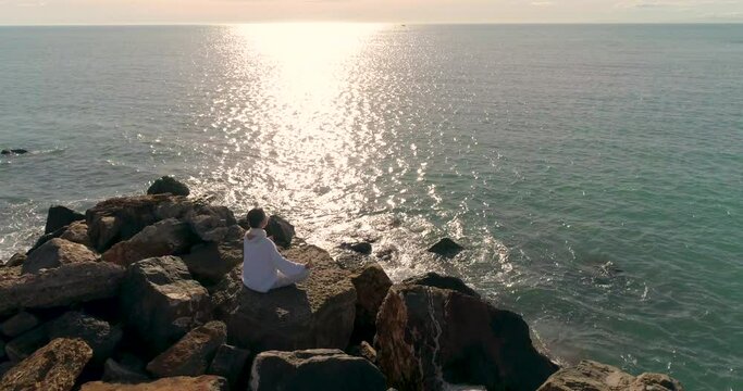 mujer median edad sentada hace yoga y dron se acerca