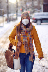 Middle-aged brunette woman in winter clothes wearing face mask outdoors due to Corona virus outdoors while on her way to work