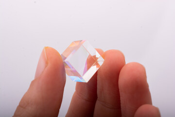 Optical glass cube in hand  Light dispersion,spectrum. Physics optics ray refractions