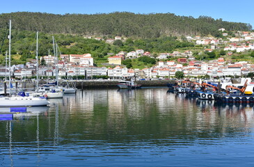 Fototapeta na wymiar Harbor and coastal village with galician fishing boats and sailing boats at famous Rias Baixas in Galicia Region. 