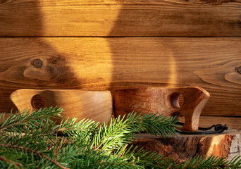 Two traditional Finnish wooden kuksa cups stand on a birch stump next to the sauna.  Fir branches...