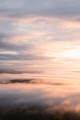 Fototapeta na wymiar Amanecer en la cima de una montaña con nubes .