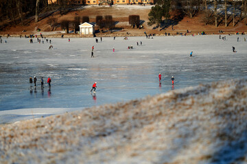 Walking for just the walk is a favorite activity in Norway. Families are gathering at the frozen lake for skating and having fun. It is a cold Sunday in January .
