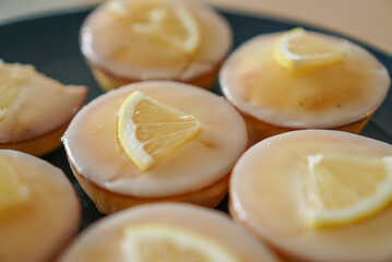 Moist and Sweet Lemon Butter Cake flavored with Lemon Juice Glaze Icing and Zest, garnished with a lemon slice. Soft and Sour Cream Lemon Dessert, putting on a dark blue plate.