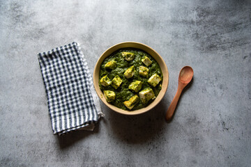 Palak paneer or cottage cheese cubes in spinach curry in a bowl.