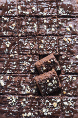 Chocolate brownie squares with nuts, top view, vertical orientation. Flat lay food