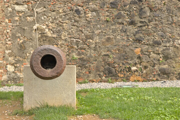 old cannon in front of stone wall