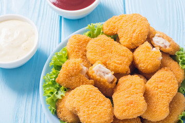 Chicken nuggets in plate on rustic background