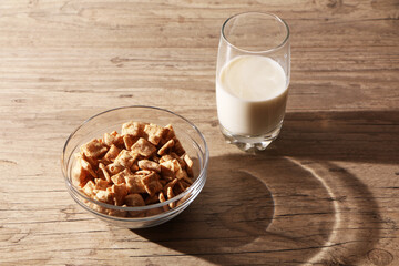 Healthy food - a glass of milk and a quick breakfast in a plate are on a wooden table.