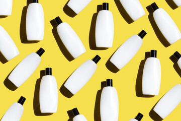 Pattern of the cosmetic bottles on the illuminating yellow background. Cosmetics flat lay. copy space. Trendy color of the year 2021