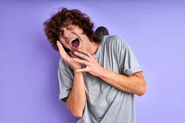 male shouts fearing decorative rat isolated over purple background, male is suffering from musophobia