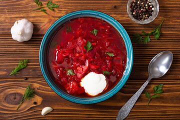 Homemade bowl with borscht and herbs