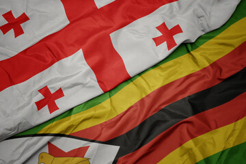 Fototapeta premium waving colorful flag of zimbabwe and national flag of georgia.