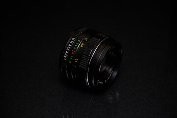Lens from the USSR on a black background and glass