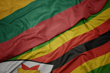 waving colorful flag of zimbabwe and national flag of lithuania.