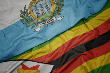 waving colorful flag of zimbabwe and national flag of san marino.