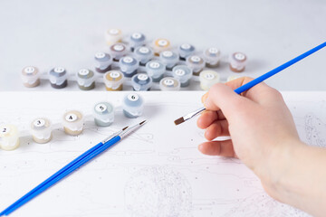 Girl hand drawing picture by numbers for beginner artist. Hobbies for stay home isolation,...