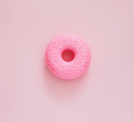 Top view pink donut on a pink background. Junk food minimal concept.