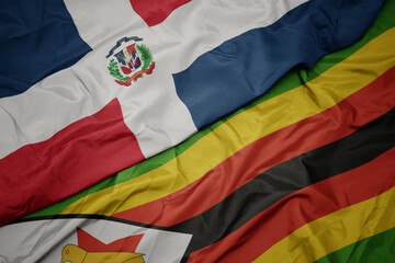 waving colorful flag of zimbabwe and national flag of dominican republic.