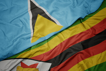 waving colorful flag of zimbabwe and national flag of saint lucia.