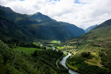 Fototapeta na wymiar Village in the valley in the middle of mountains and forests in Norwegian rural countryside. Norway