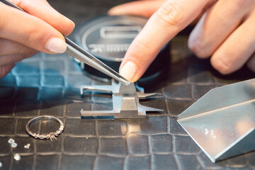 Close-up of jeweler sorting diamonds on her workbench
