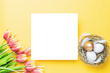 Naklejka na ściany i meble Easter set. Golden, white colour egg in basket with spring tulips, feathers on pastel yellow background in Happy Easter decoration. Traditional design with copy space.