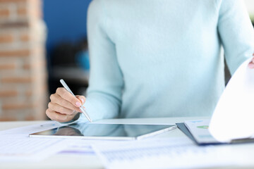 Business woman holding stylus in hands over tablet closeup