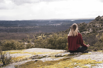 Fototapeta premium Woman performs yoga moves on mountain summit