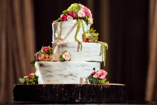 Three-tiered wedding cake in the form of a birch tree with fresh flowers