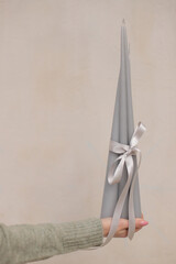 Extinguished candle in woman hand. Beautiful grey candles. Special gift.
