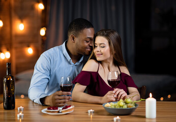 Passionate Interracial Couple Having Romantic Dinner At Home, Drinking Red Wine Together