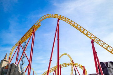 summer blurred photo of Rollercoaster against blue sky