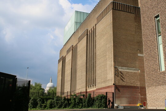 London England - 23 June 2018: Exterior of vast large brick building of the Tate Modern Art Gallery on the Southbank London on river Thames on warm Summer holiday with St Paul's Cathdedral background