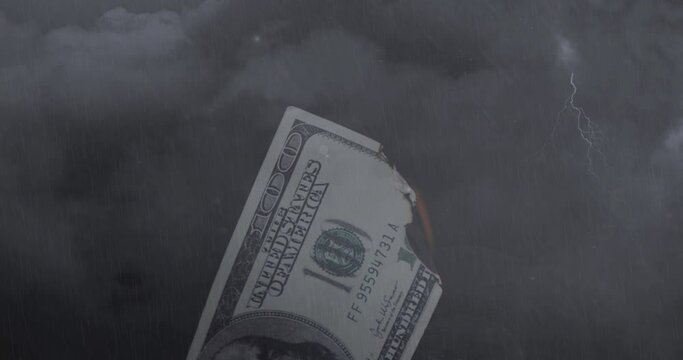 Digital composition of burning american dollar bill against thunderstorm in night sky