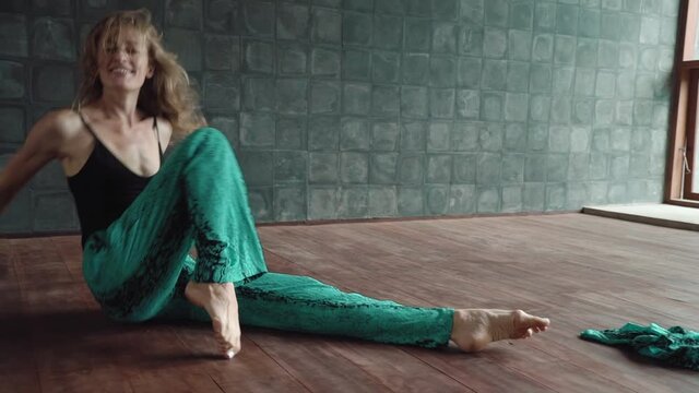 Young adult european woman performing contemporary dance improvisation in studio. Graceful modern style dancer expressing inspiration and emotions in dance moves.