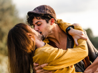 Passionate young ethnic boyfriends embracing and kissing each other while having intimate moments during romantic date in nature