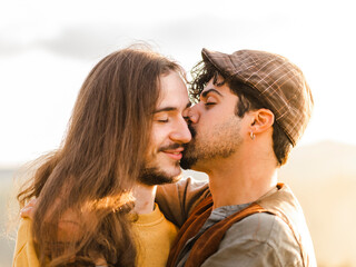 Passionate young ethnic boyfriends embracing and kissing each other while having intimate moments during romantic date in nature