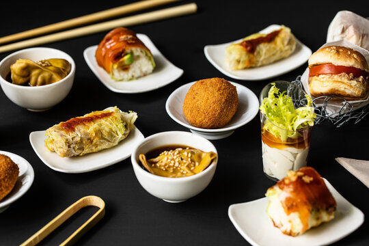 Top View Of Various Tasty Fusion Food Arranged On Black Table In Restaurant