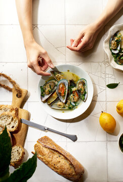 Cooked kiwi green mussels with wine, garlic and parsley served with baguette and butter with herbs