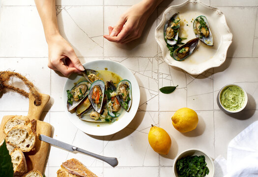 Cooked kiwi green mussels with wine, garlic and parsley served with baguette and butter with herbs