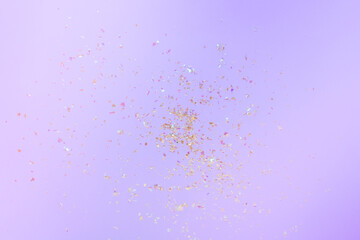 Golden flying sparkles on bright holiday background. Festive backdrop 