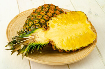 Exotic fruits. Ripe sweet ripe pineapple on wooden background. Studio Photo