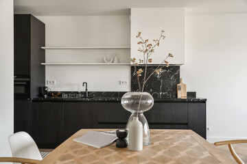 Kitchen interior with marble elements and a dining table. Stylish kitchen with black furniture....