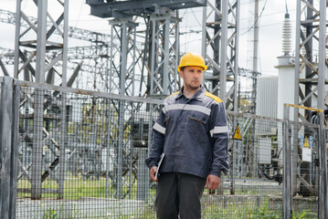 An engineering employee makes a tour and inspection of a modern electrical substation. Energy. Industry