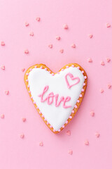 Heart shaped cookie with word LOVE on pink background