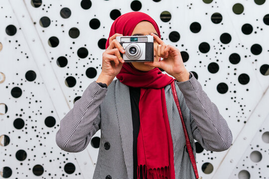 Arab Female In Red Headscarf Standing In City With Retro Photo Camera And Taking Picture